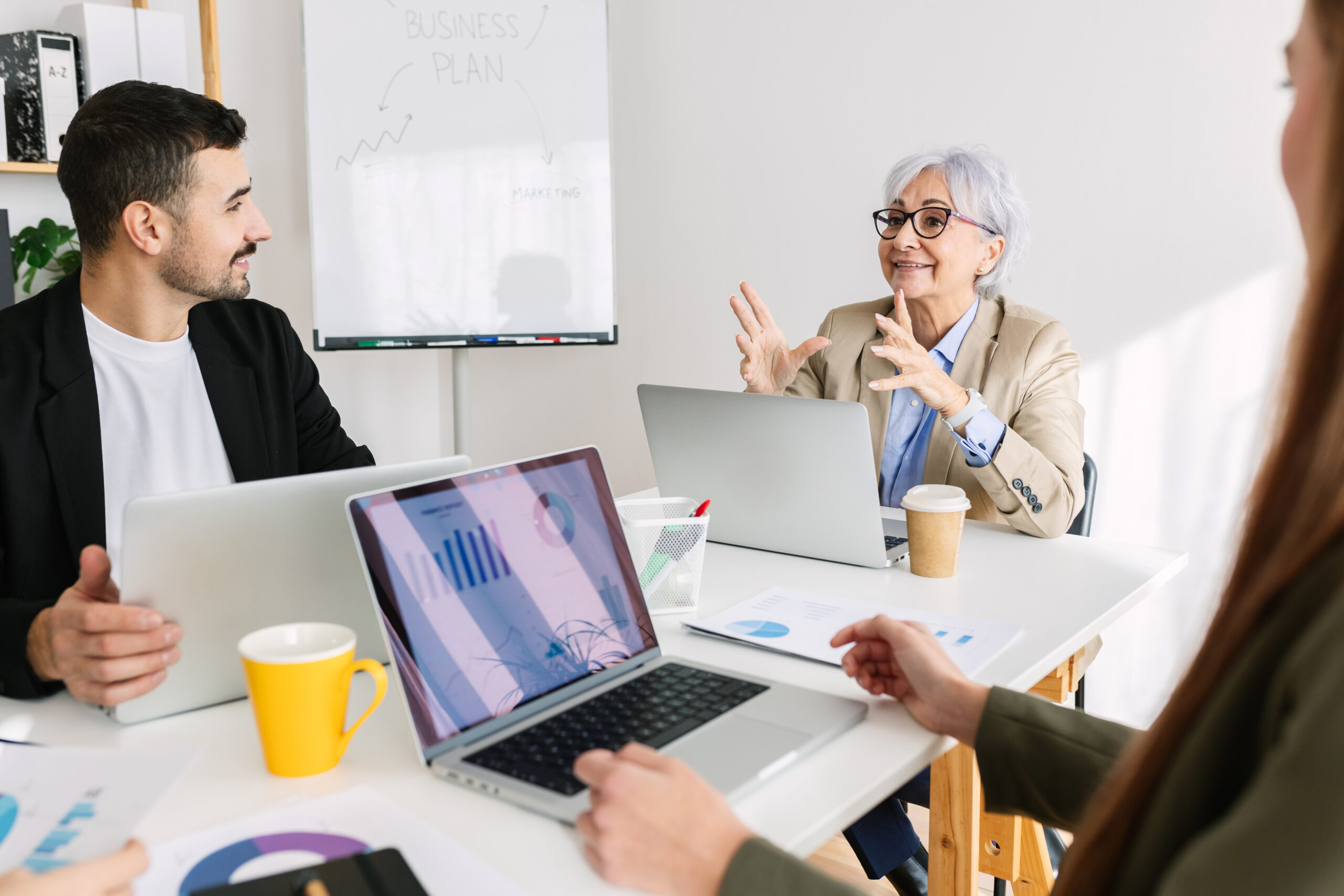 Group of professional business colleagues sitting at meeting room discussing about corporate project